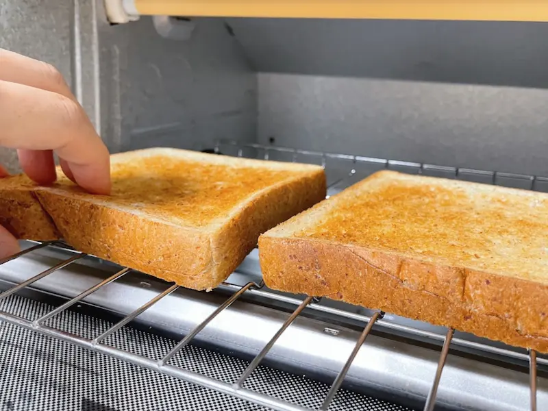 トースターに入れた食パンが焼きあがった画像