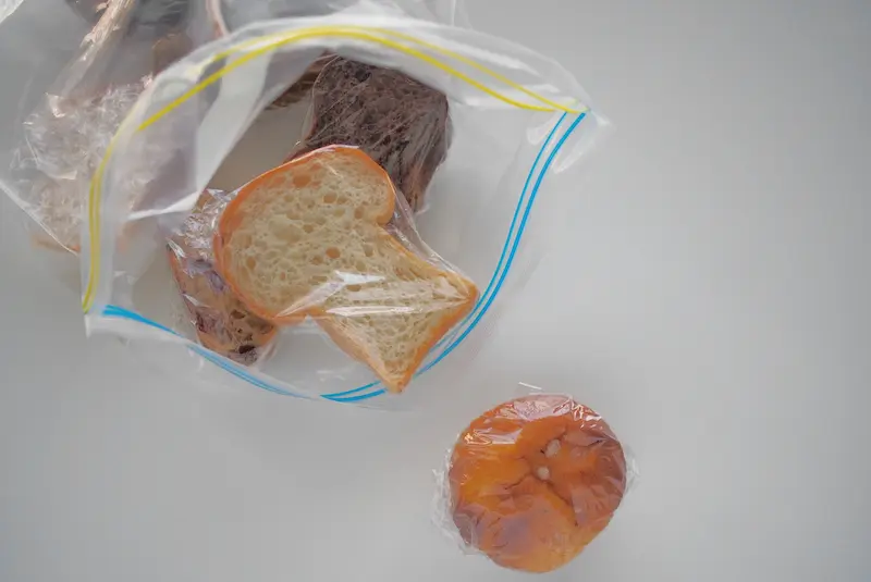 パンを一つずつラップしてジッパー付きの袋に入れている画像